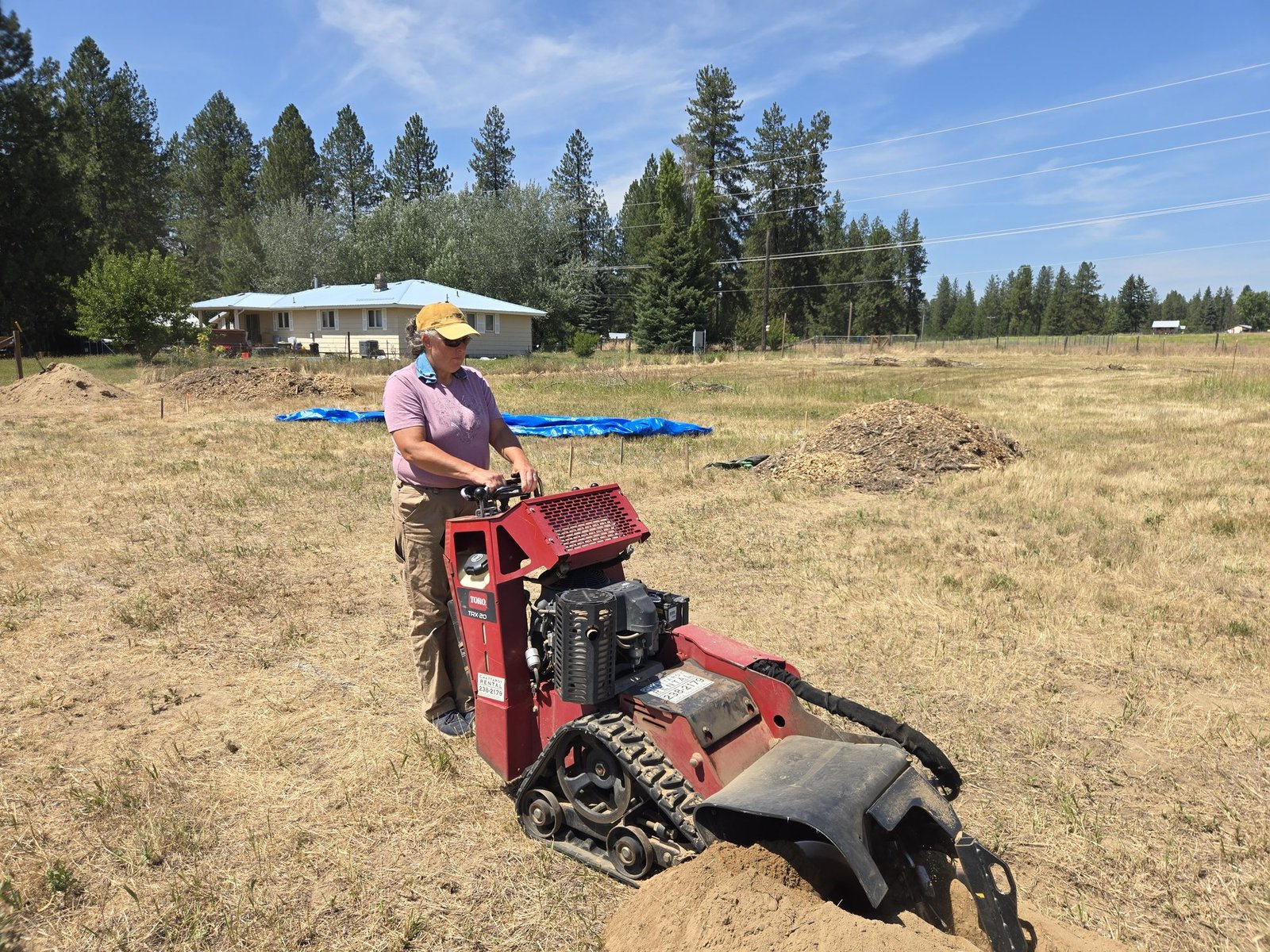 Tina running the trencher for irrigation lines